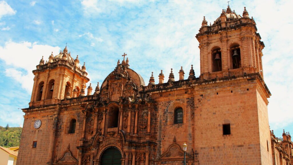 Fachada detallada de la Iglesia de la Compañía de Jesús en Cusco con cielo despejado.