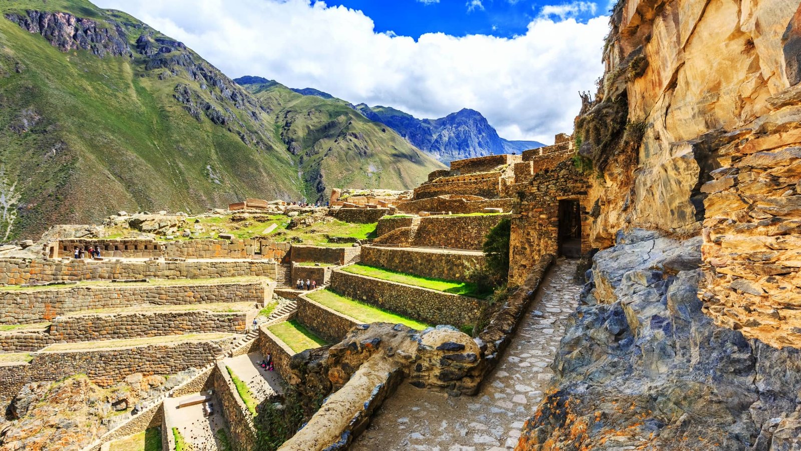 Estructuras incas y terrazas empinadas en Wiñay Wayna rodeadas de densa vegetación verde.