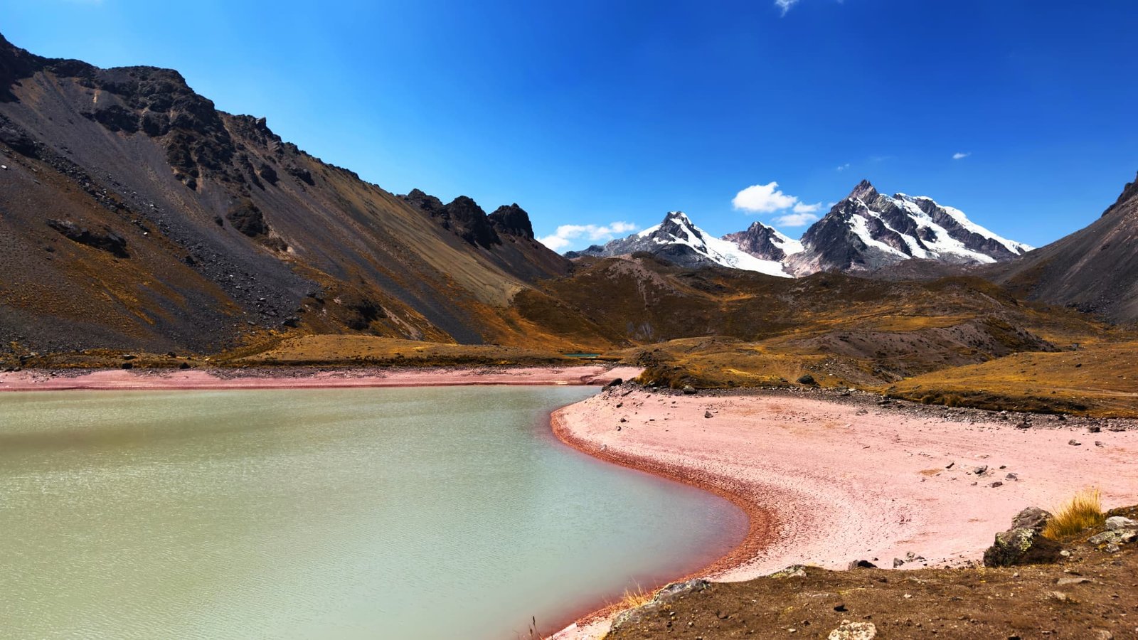 Laguna andina con sedimentos minerales en la orilla, circuito 7 lagunas Ausangate
