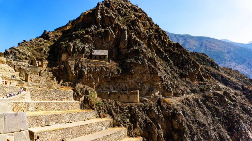 Ruinas de una fortaleza de piedra de color rojizo situada sobre una colina en los alrededores de Cusco.