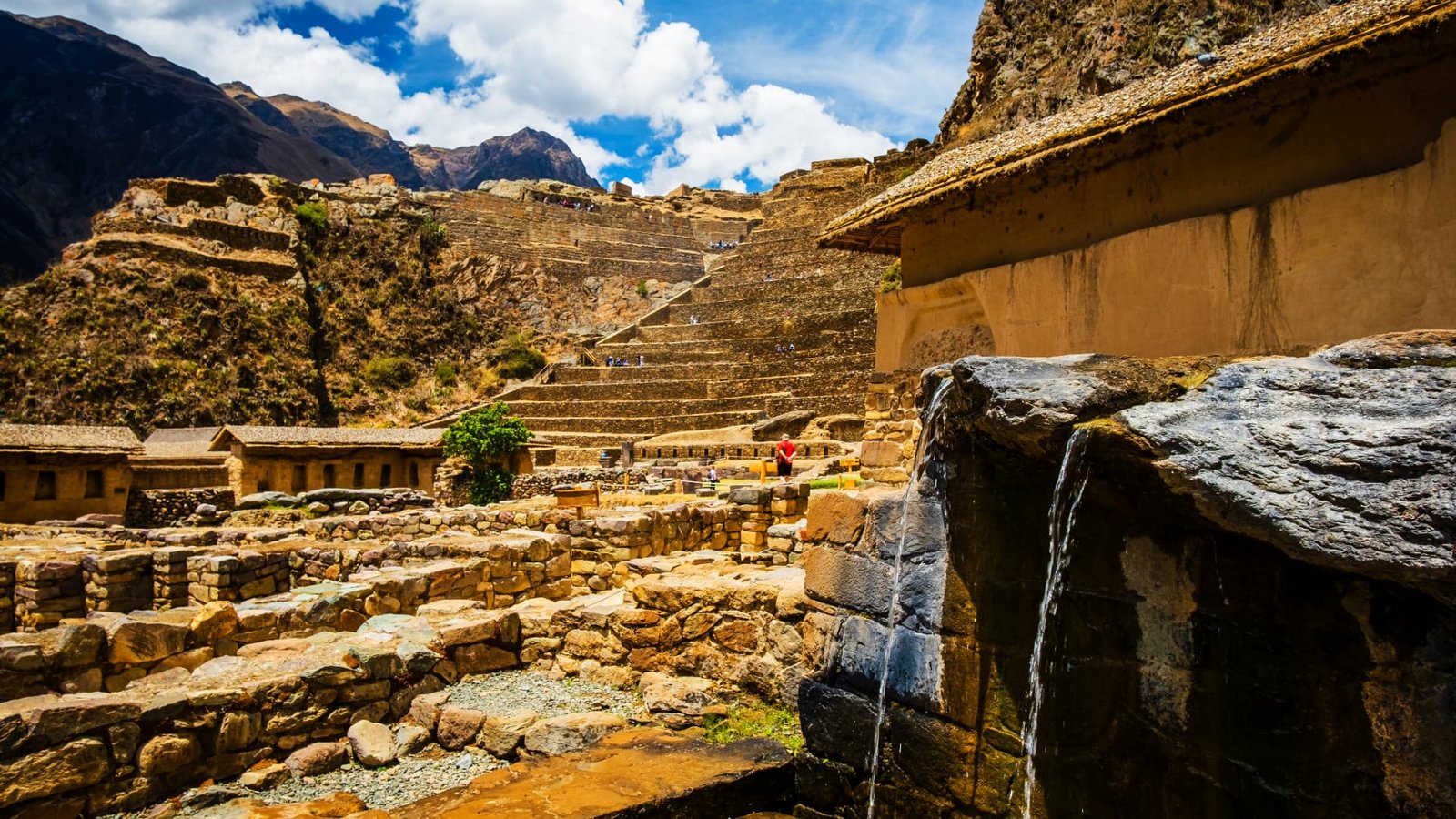 Canales de piedra con agua fluyendo en el sitio arqueológico de Ollantaytambo.
