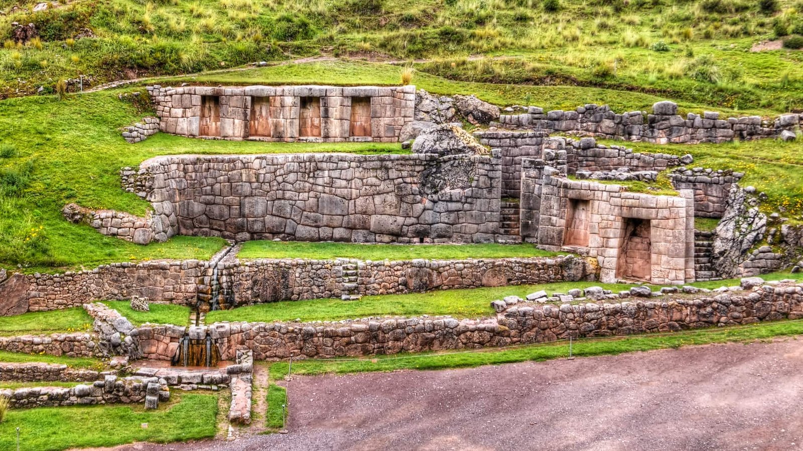 Muros de piedra y andenes agrícolas rodeados de vegetación en Tipón.
