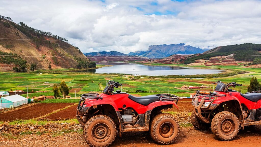 Cuatrimoto roja estacionada frente a una laguna azul en el altiplano.