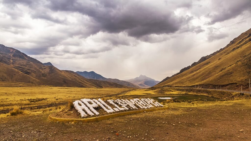 Letras blancas grandes sobre el campo con montañas de fondo en el altiplano.