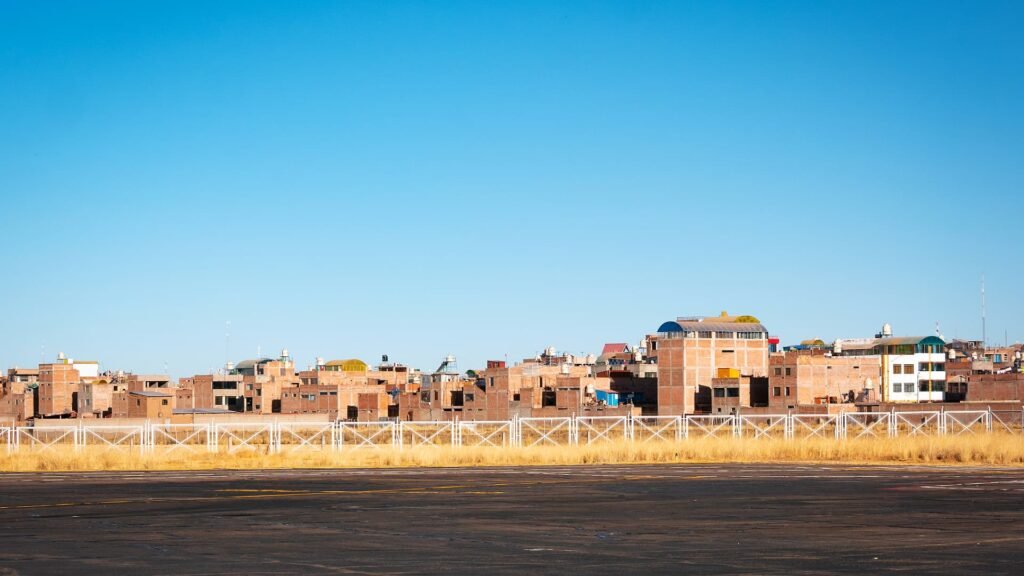Vista de un pequeño pueblo rural con casas de adobe y ladrillo en medio de las montañas del altiplano.