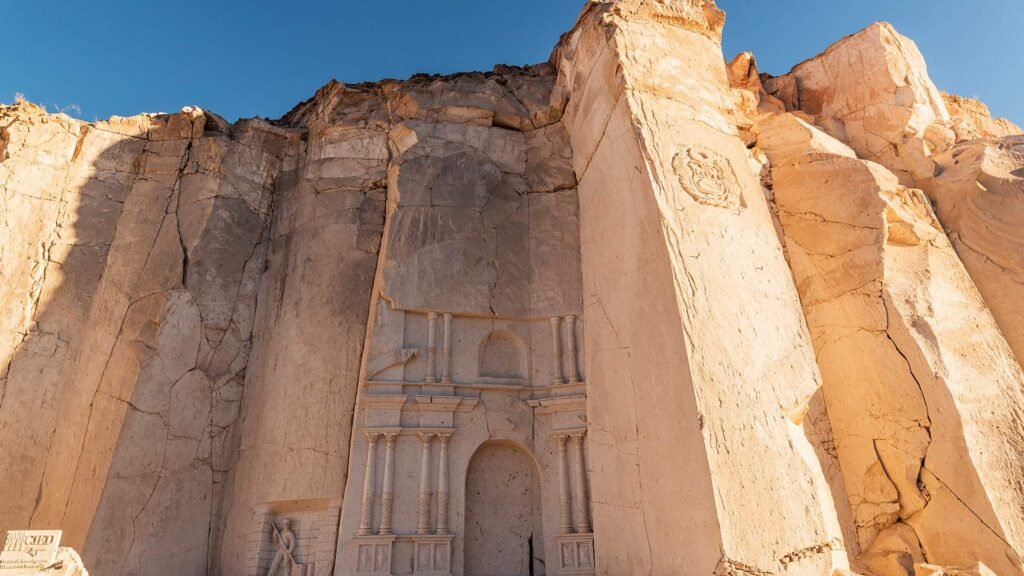 Arco y fachada detallada esculpida en una pared de sillar blanco en la zona de las canteras.