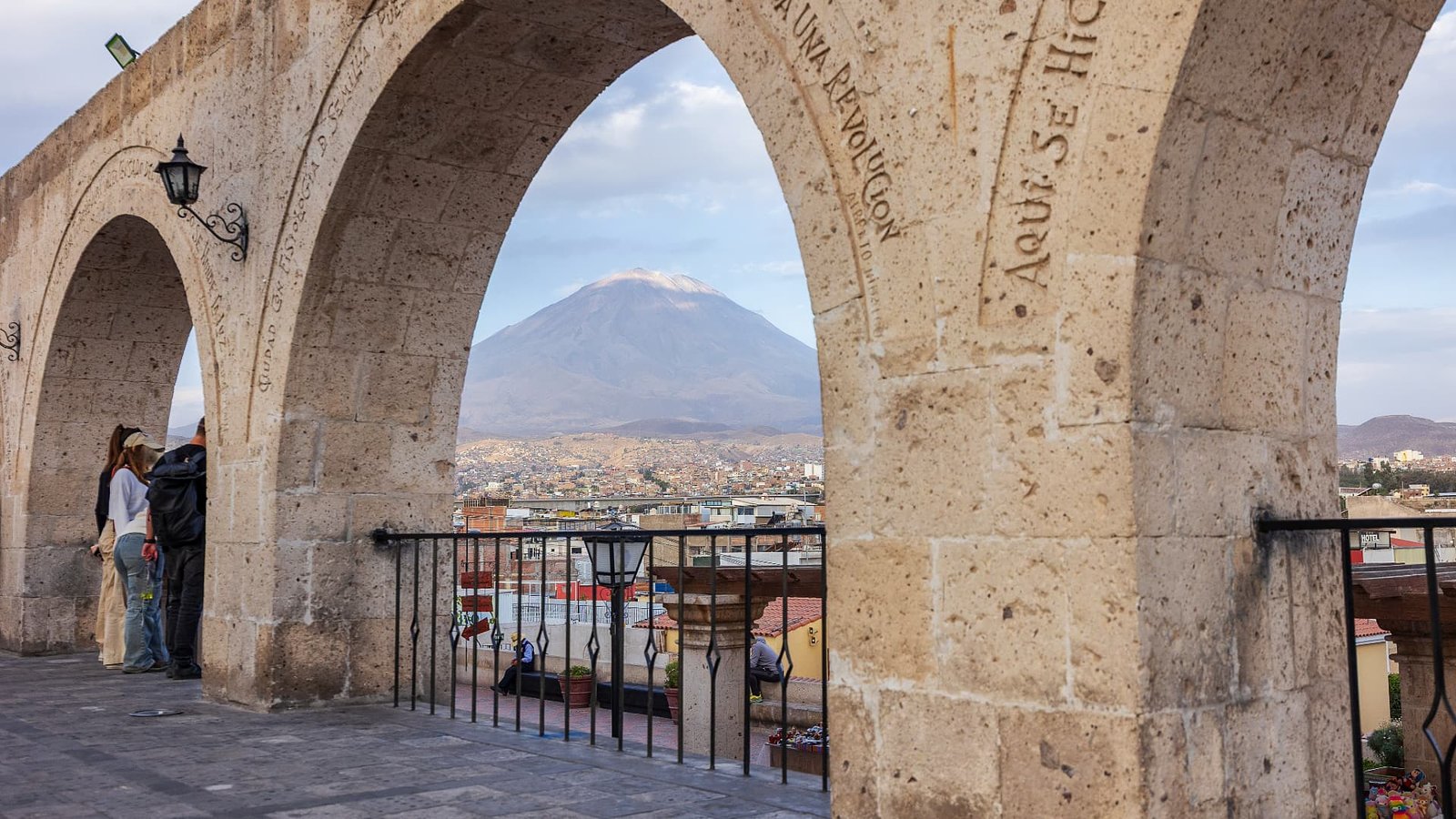 Vista del volcán Misti enmarcado por un arco de piedra de sillar con grabados en el mirador de Yanahuara.