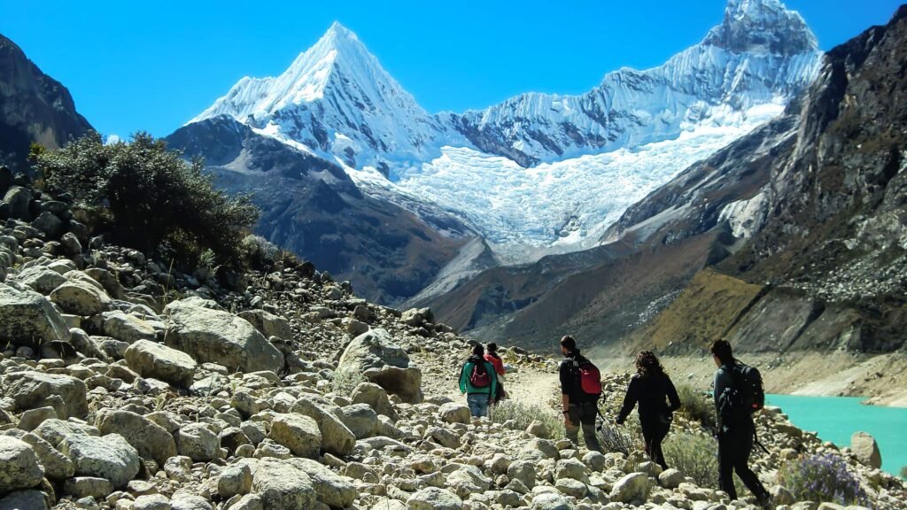 Excursionistas caminando hacia un pico nevado en los Andes.