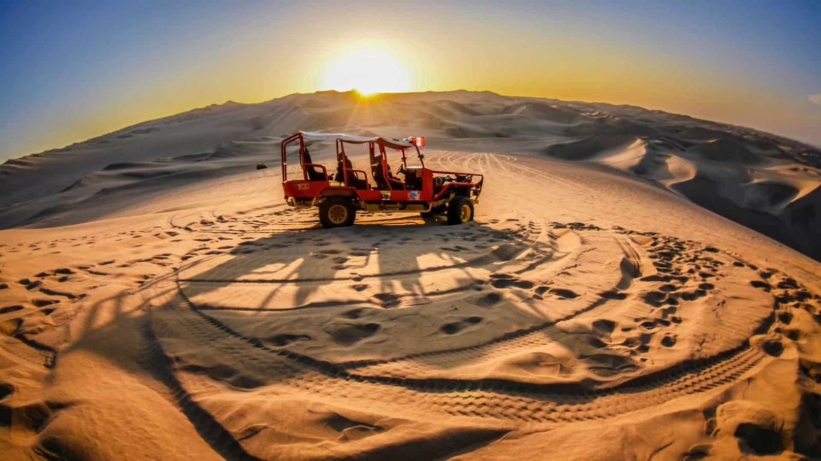 Arenero buggy en las dunas de Huacachina durante el atardecer.