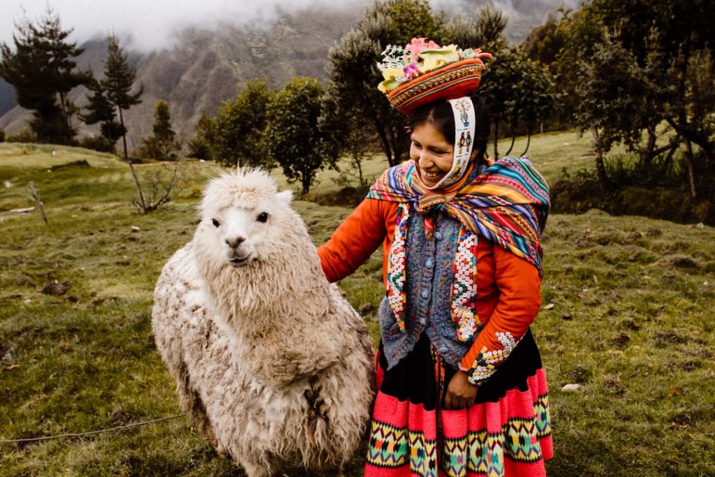 Turismo sostenible en Perú con viajeros recorriendo una comunidad andina.